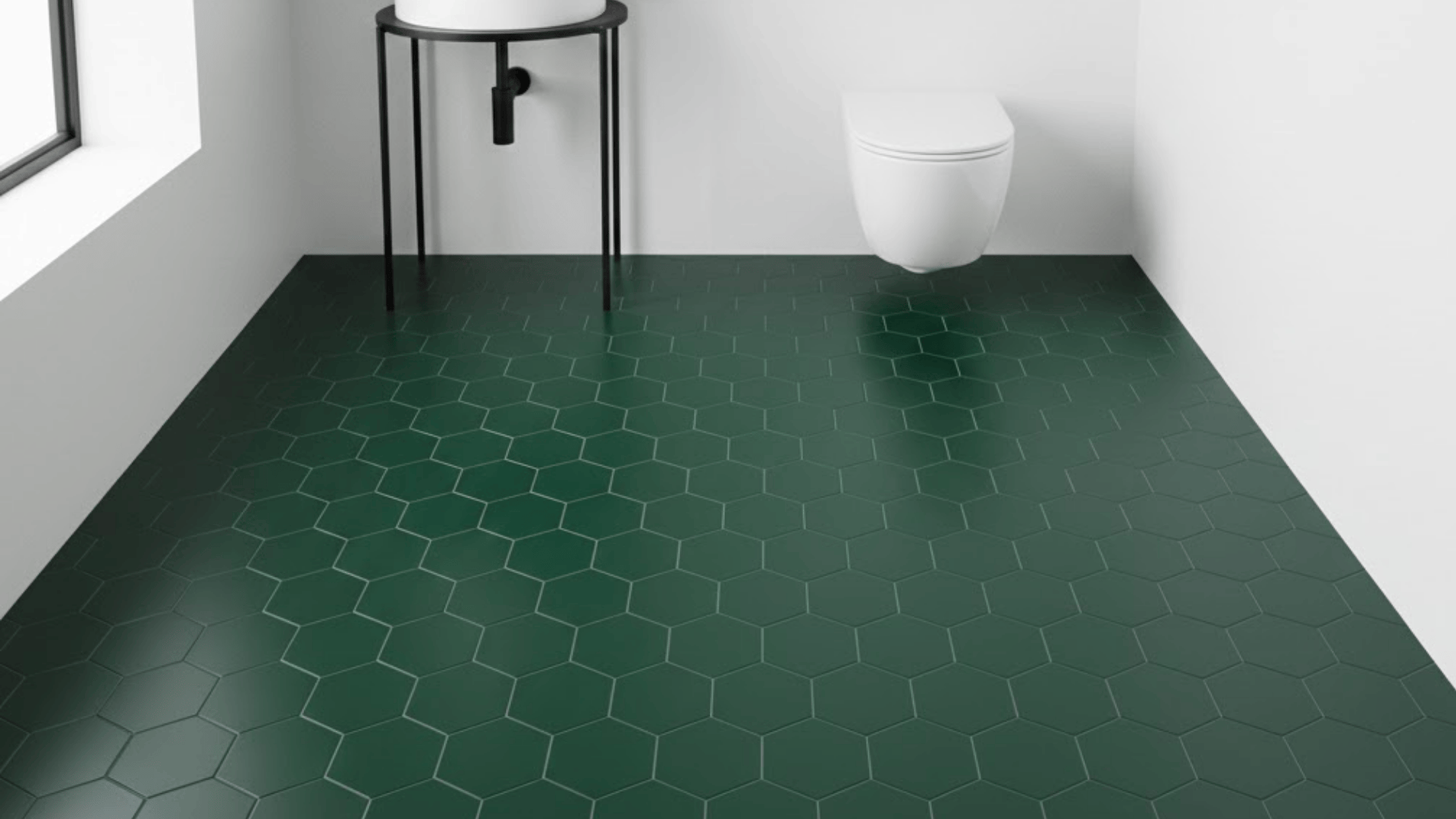 Dark green hexagon floor tiles in a minimalist bathroom with a white toilet and black stand.