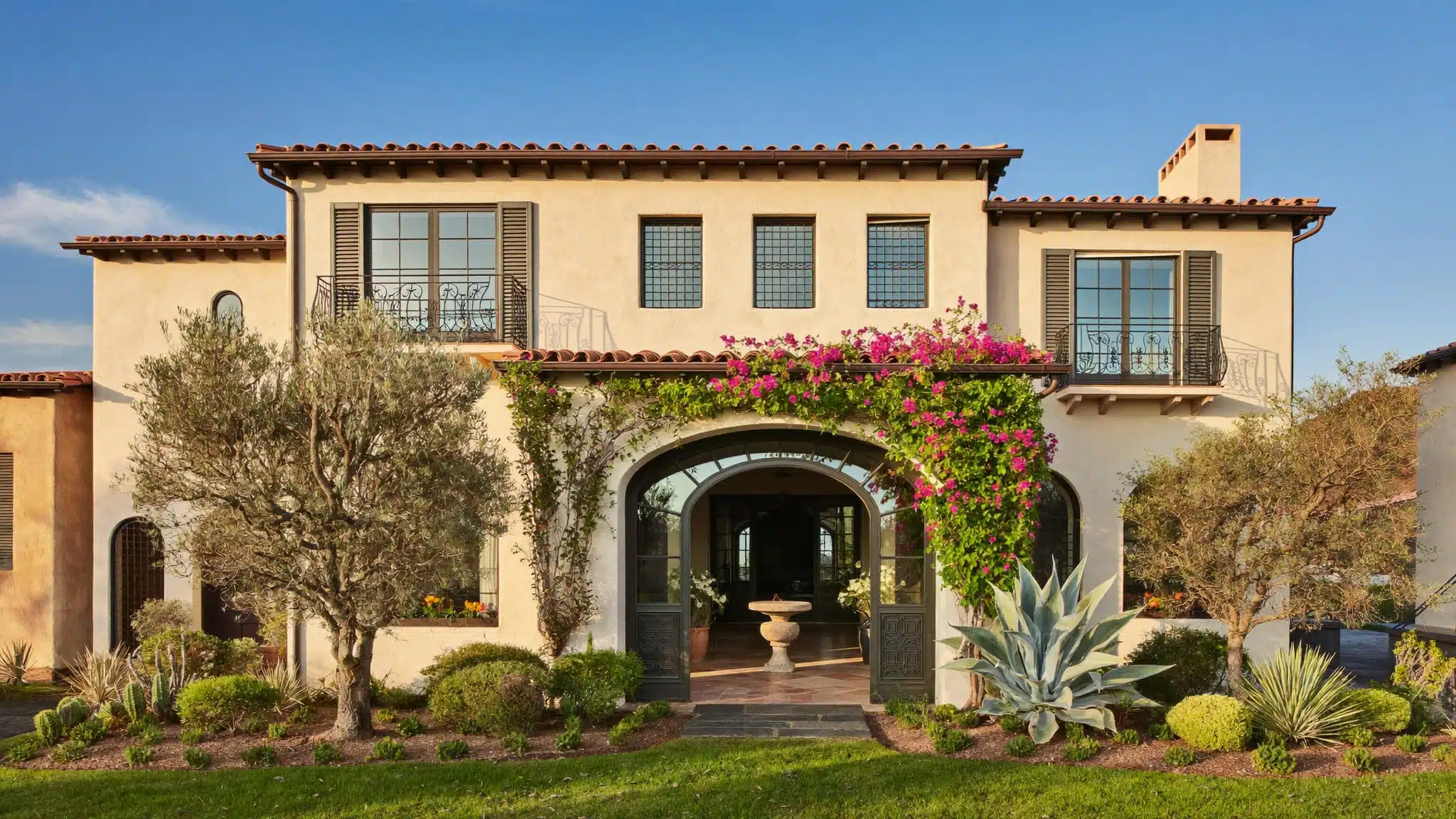 A Mediterranean-style villa featuring a red clay tile roof and white stucco walls.