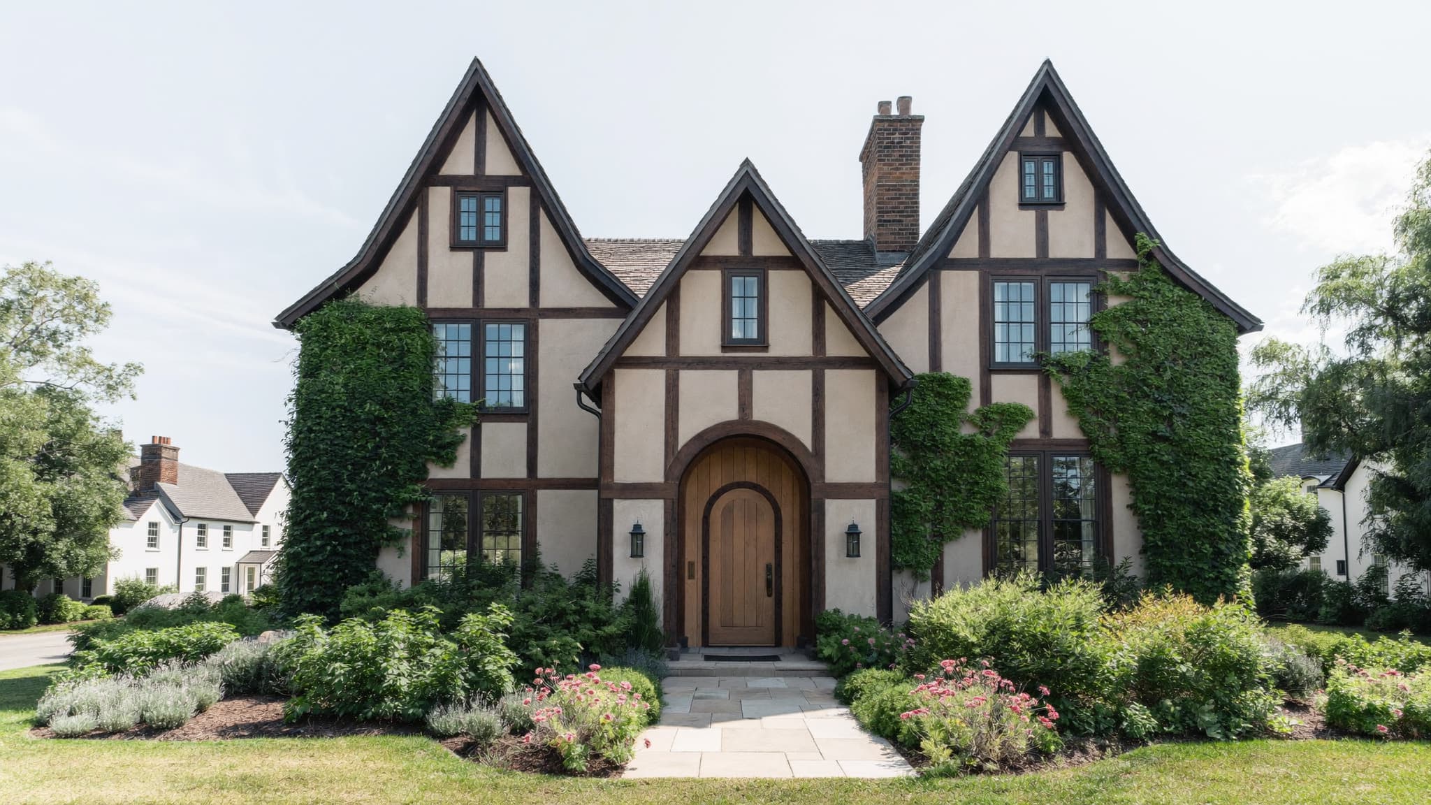 A Tudor-style home with classic half-timbering, steep gables, and an arched wooden entryway.