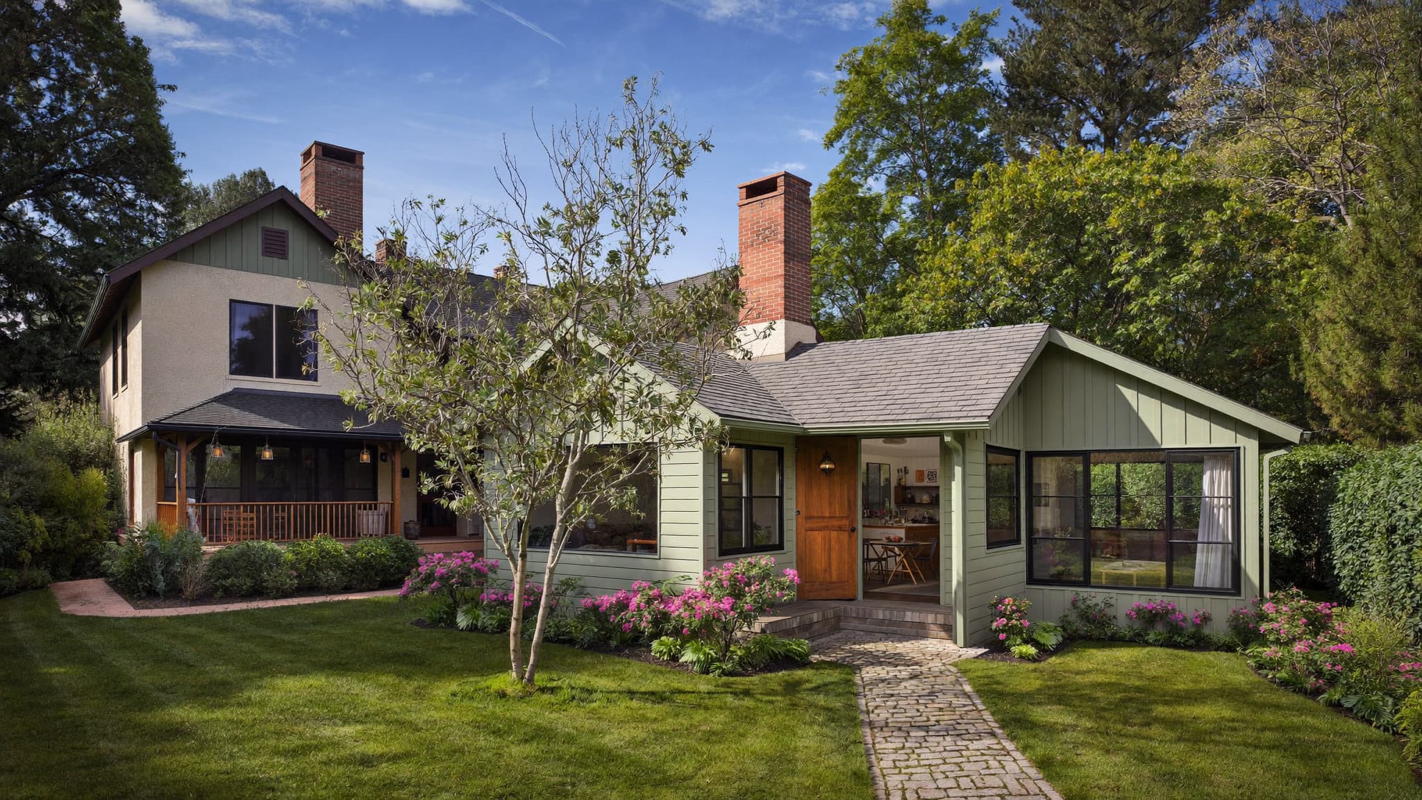 A detached backyard accessory dwelling unit located behind a larger primary residence.
