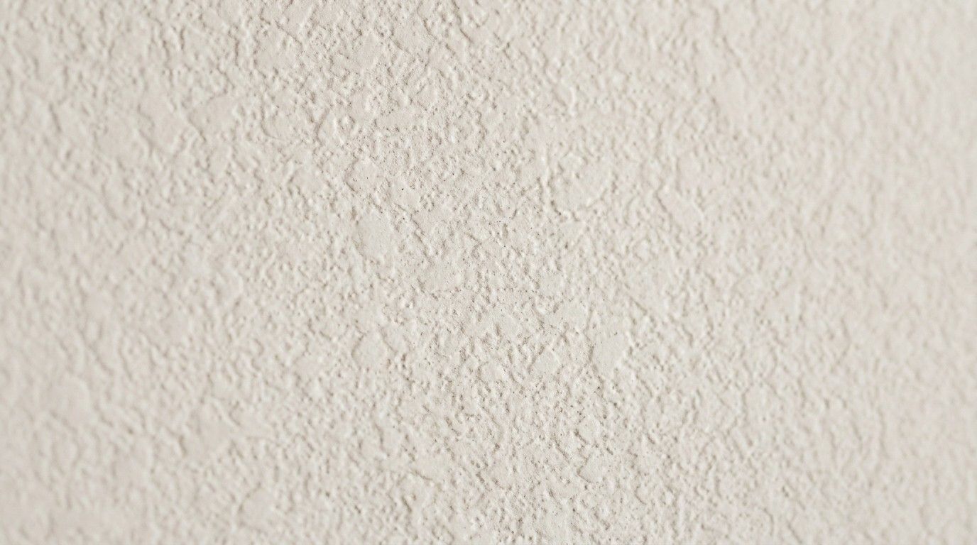 Knockdown wall texture with flattened, irregular splatter patterns creating a soft, mottled finish
