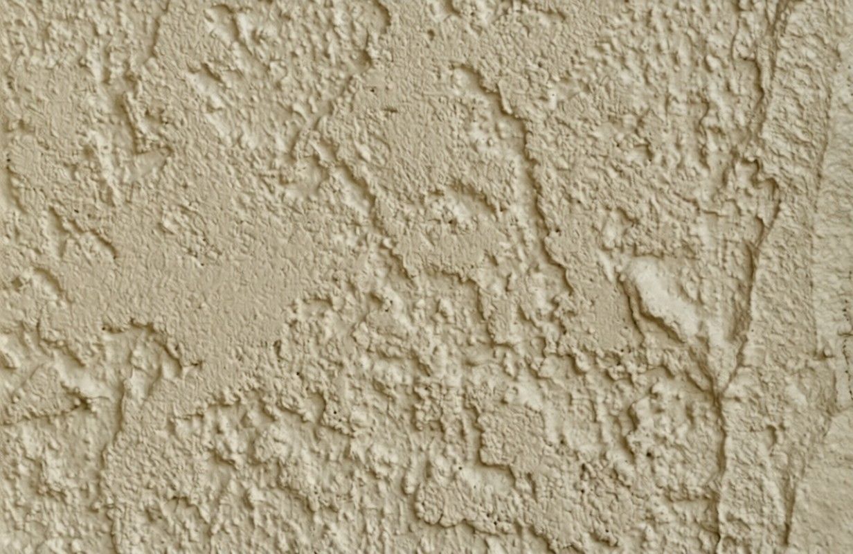 Skip trowel wall texture with uneven, hand-applied plaster creating a rustic, layered pattern