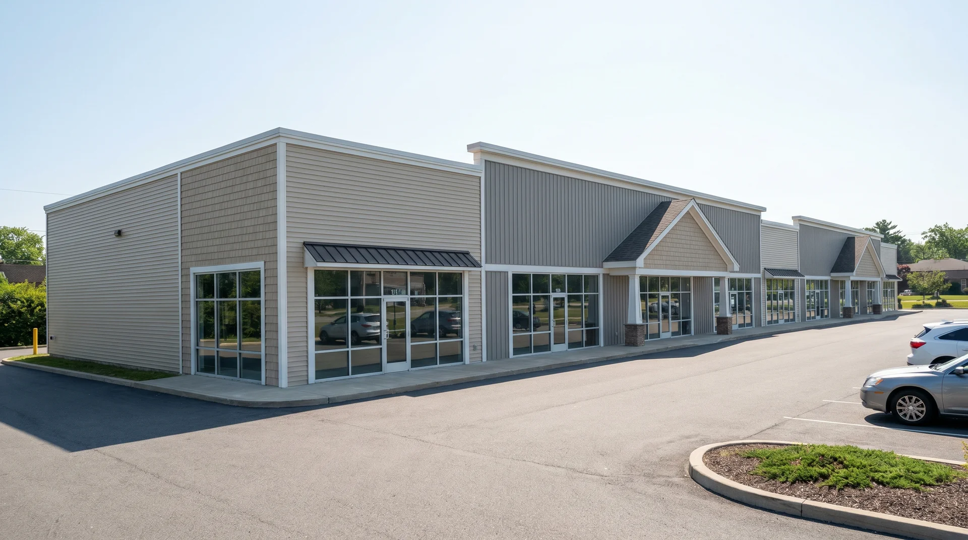 Commercial building exterior with a combination of gray horizontal vinyl siding and decorative stone veneer.