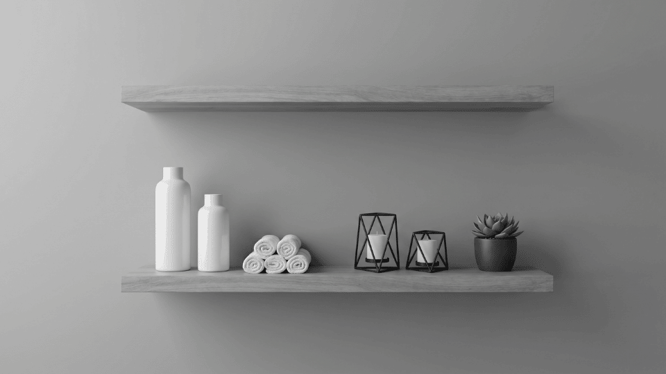 Minimal bathroom shelves in gray, styled with rolled towels, bottles, candles, and a small potted plant.